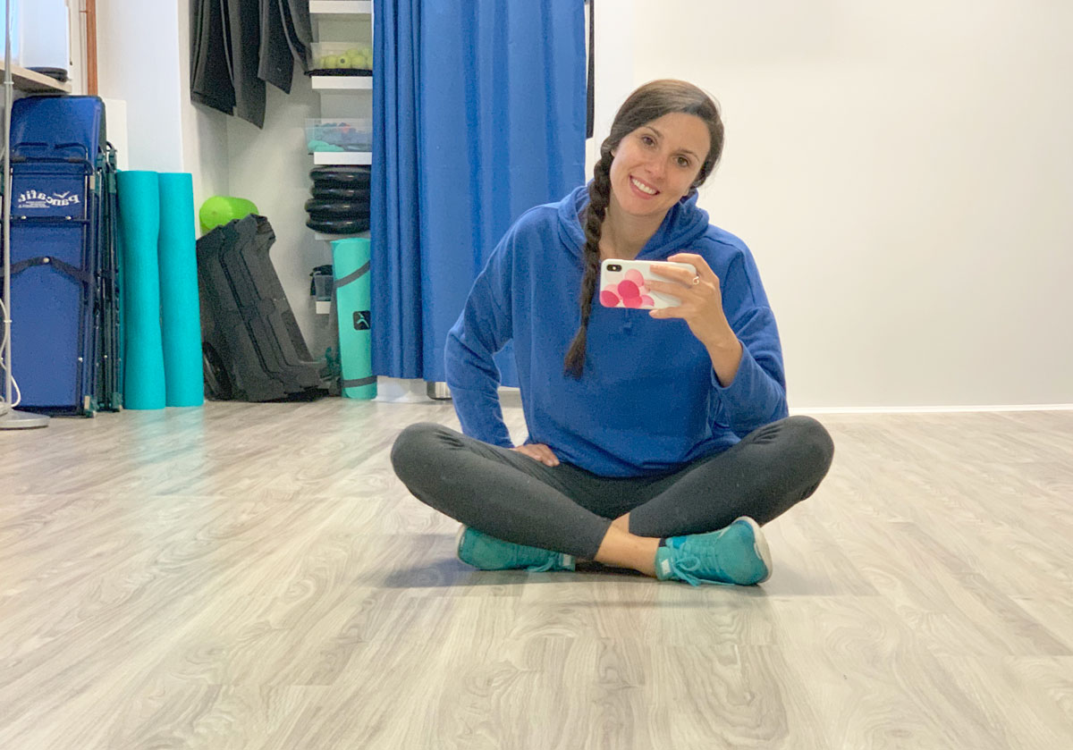 Valentina Quaglia seduta a terra in una sala di allenamento, sorridente e scattando un selfie
