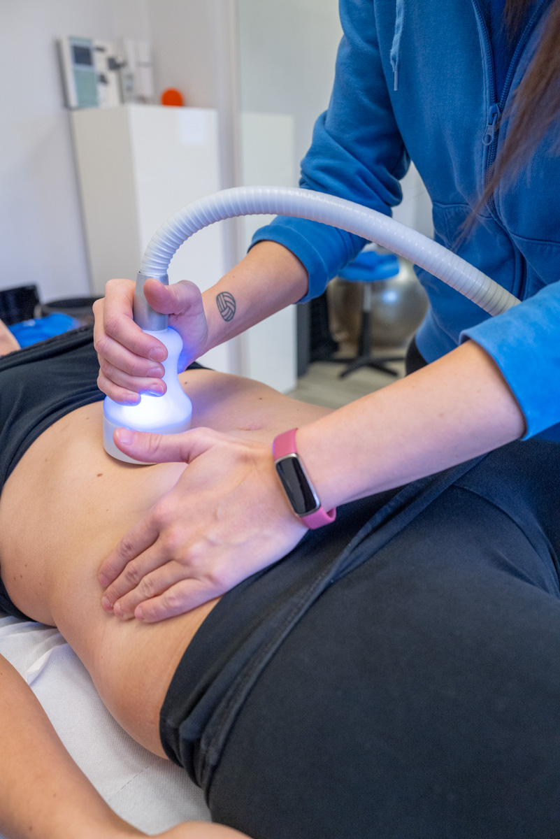 CRYO_2024_5138_WEB Operatore esegue crioterapia sull’addome di una paziente per ridurre infiammazione e dolore.