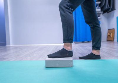 Esercizio riabilitativo con blocco per migliorare equilibrio e forza muscolare