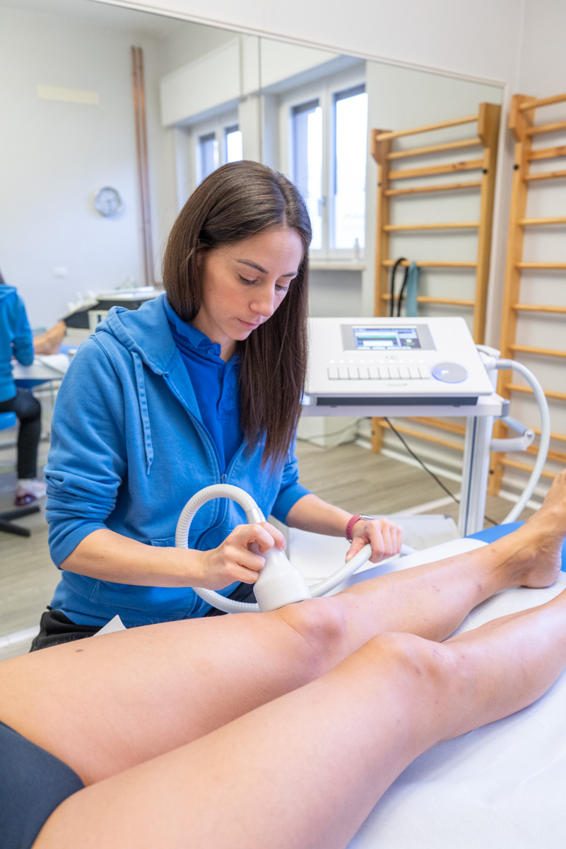 Terapista che utilizza un dispositivo Cryothermoshock sulle gambe di un paziente.