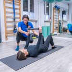 Terapista effettua una seduta riabilitativa in palestra.