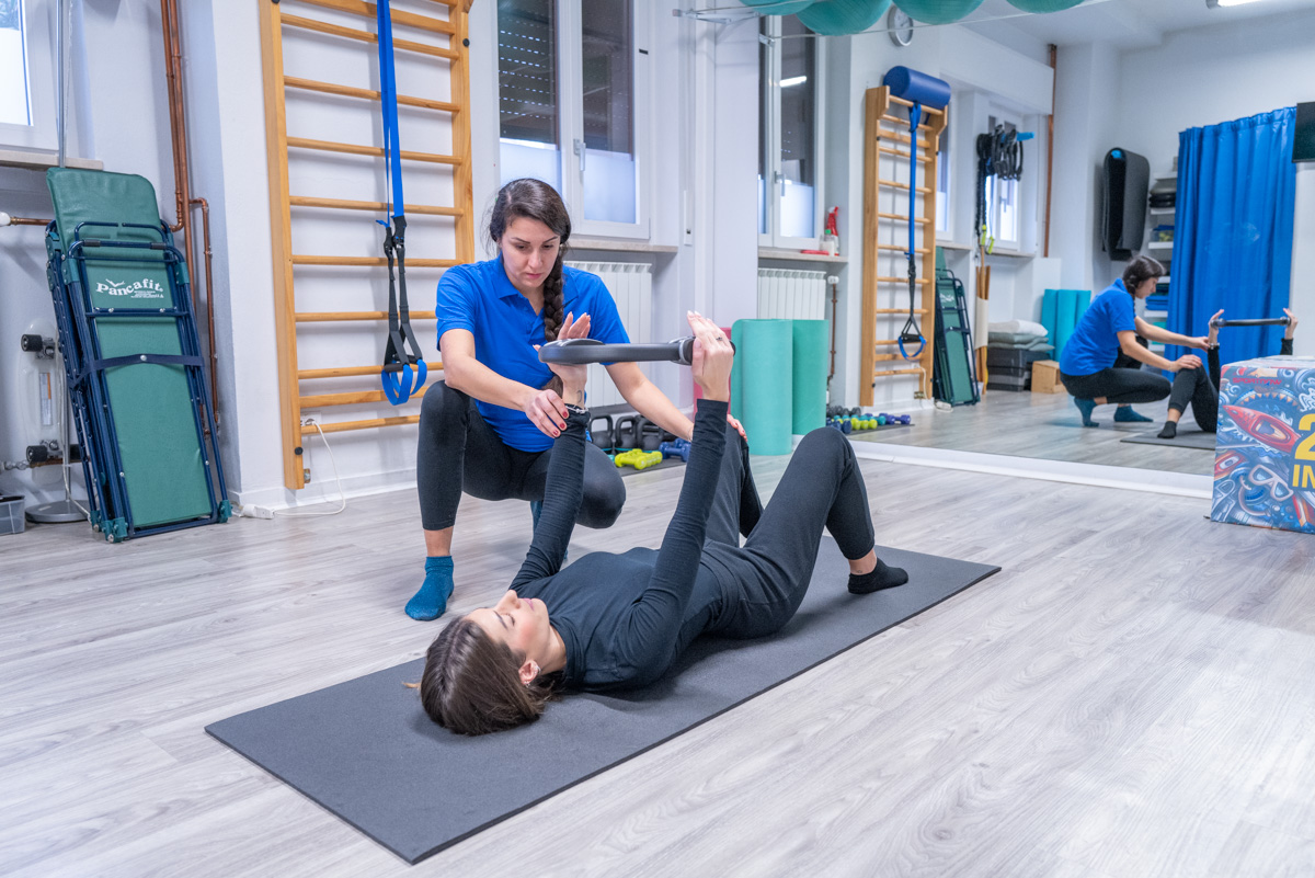 Terapista effettua una seduta riabilitativa in palestra.