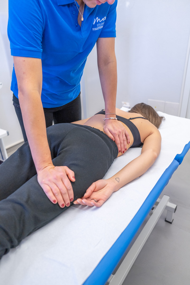 Un osteopata effettua una panipolazione su una paziente distesa sul lettino